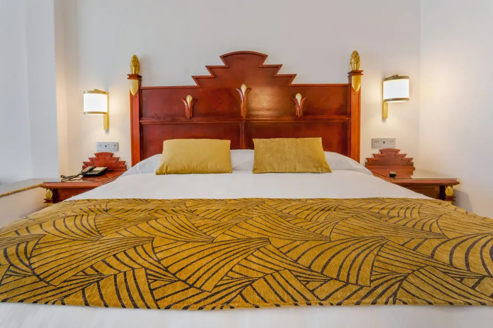 Junior Suite Ocean View king bed with carved headboard at Hotel Riu Vallarta.