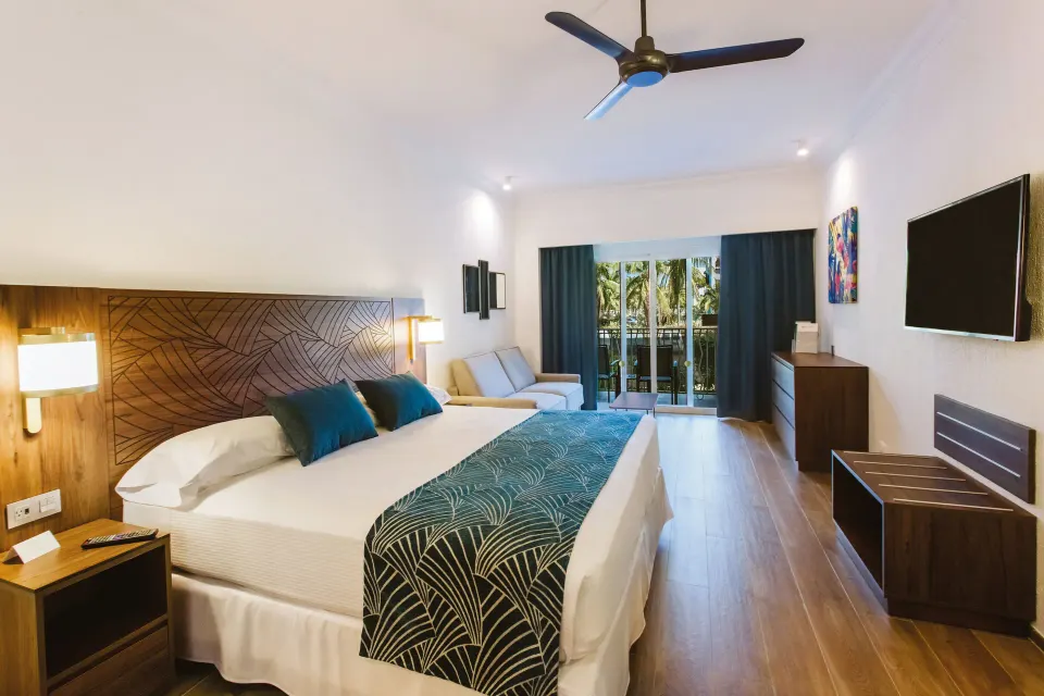 Partial Ocean View room with king bed and balcony doors at Hotel Riu Vallarta.