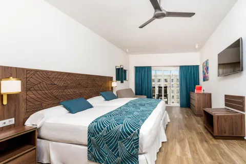 Standard Room with two beds and balcony doors at Hotel Riu Vallarta.
