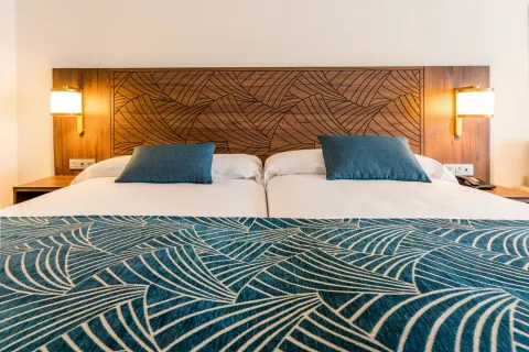Close view of Standard Room two beds and patterned runner at Hotel Riu Vallarta.