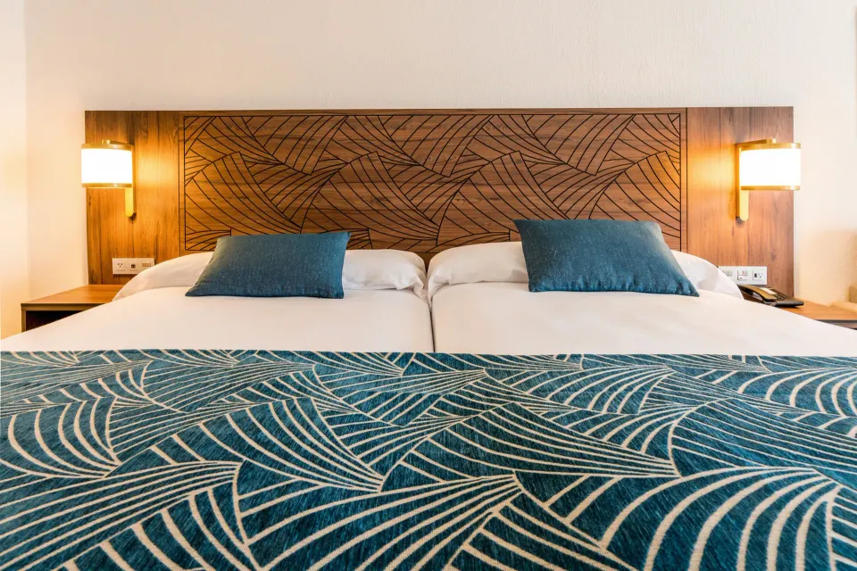 Close view of Standard Room two beds and patterned runner at Hotel Riu Vallarta.