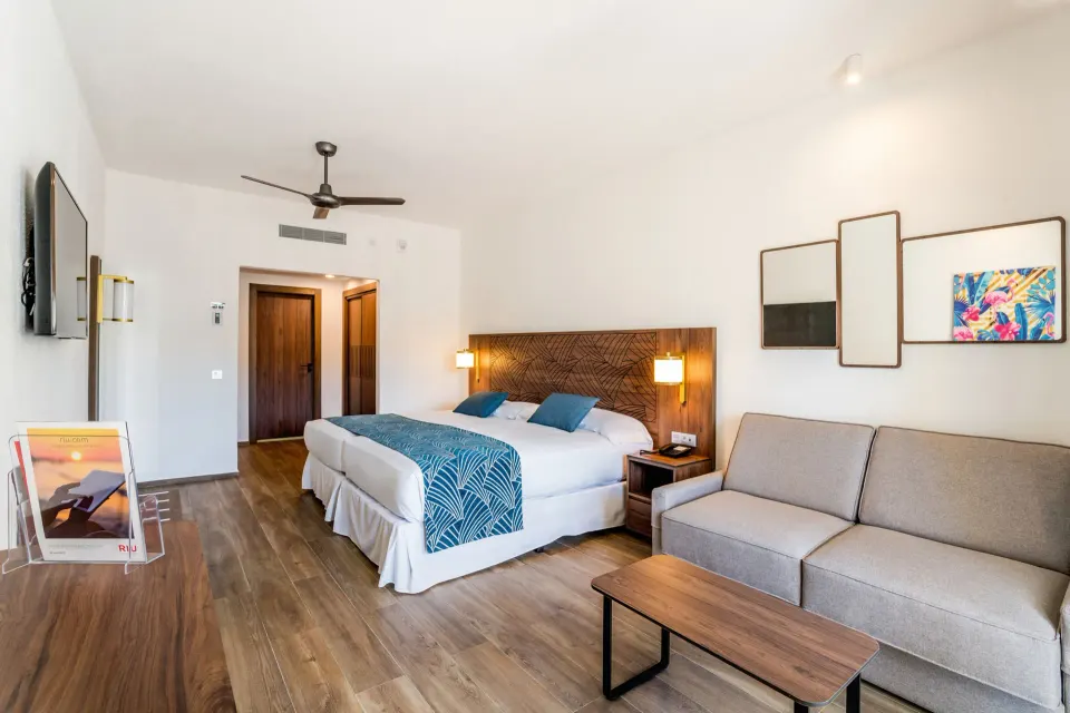 Standard Room with two beds, sofa, and coffee table at Hotel Riu Vallarta.