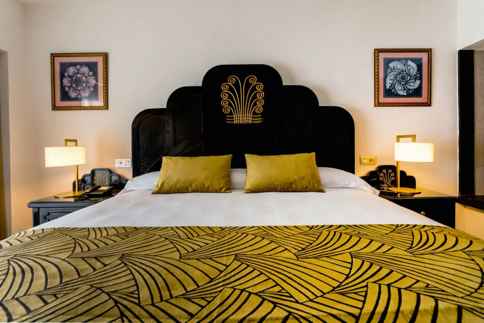 Suite Ocean View king bed with black headboard and gold accents at Hotel Riu Vallarta.