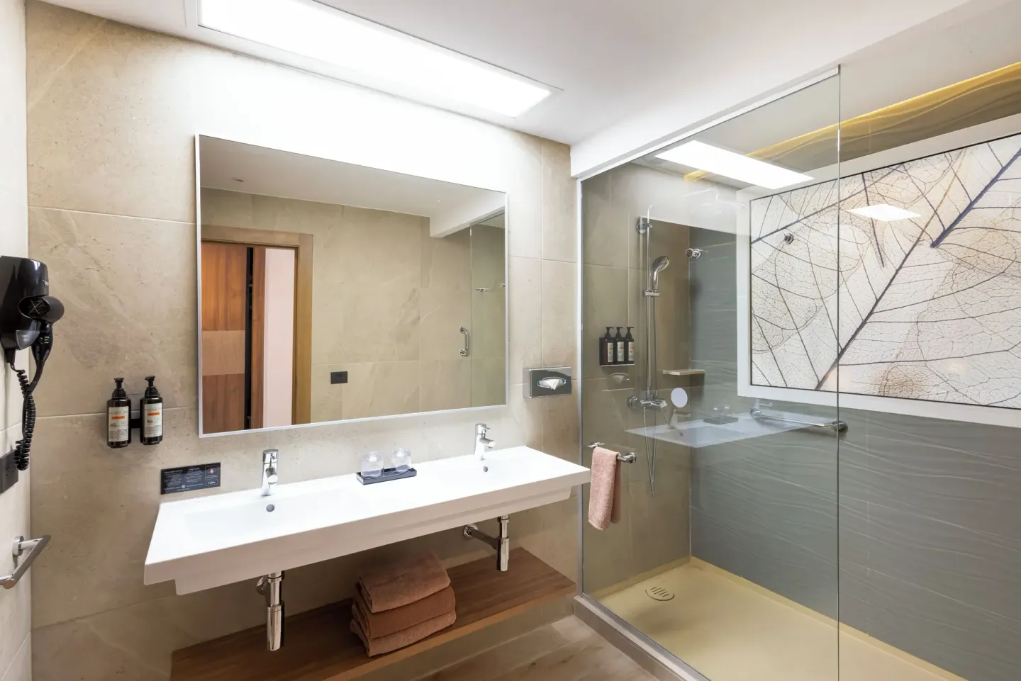 Bathroom vanity and glass shower in an ocean view swim-up room at Hotel Riu Ventura.