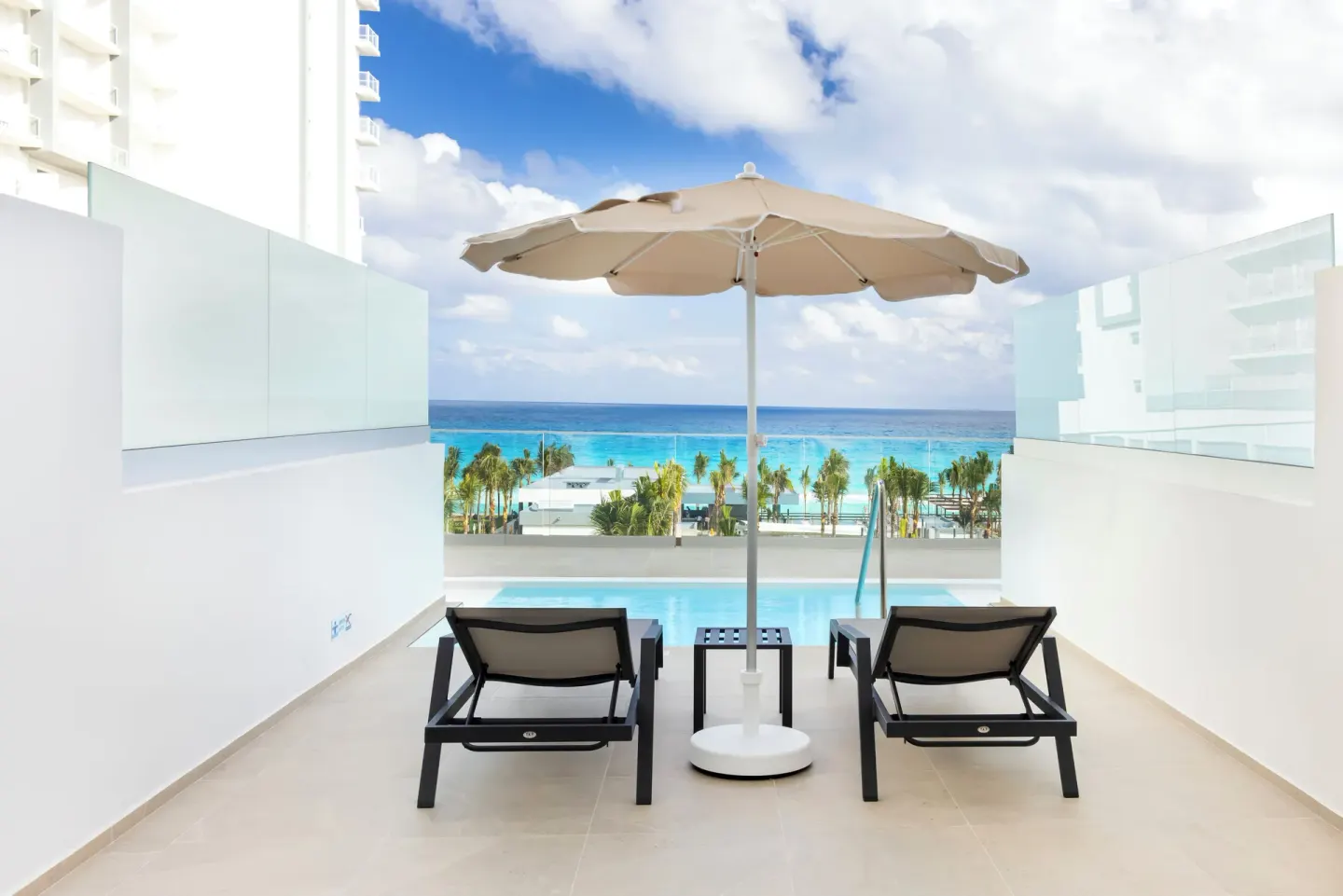 Ocean view swim-up terrace with loungers and umbrella at Hotel Riu Ventura.