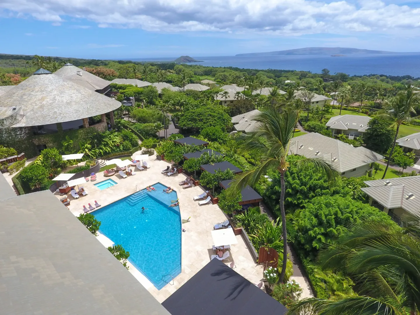 Aerial view of the pool, villas, palms, and ocean at Hotel Wailea.