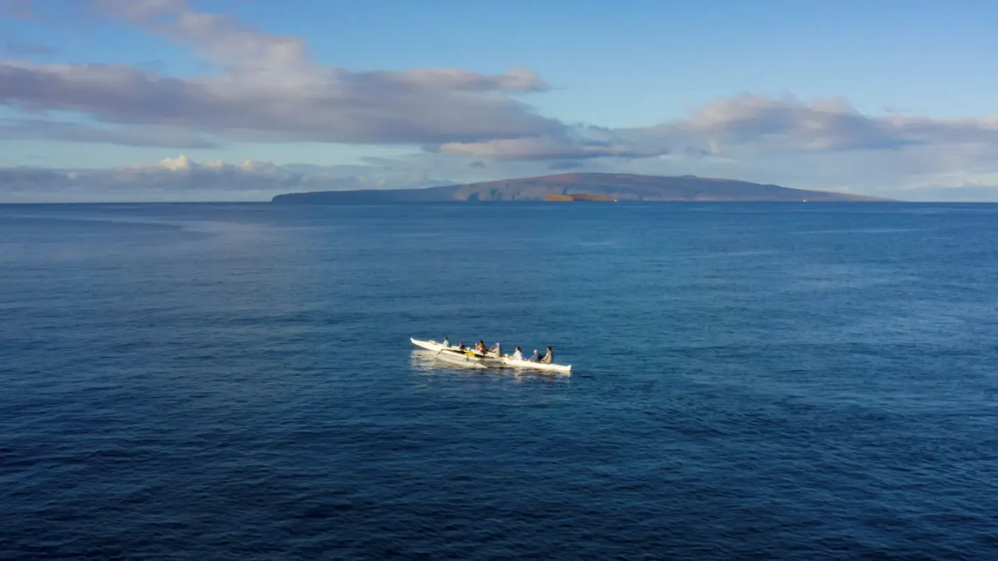 Outrigger canoe on open ocean with an island view near Hotel Wailea.