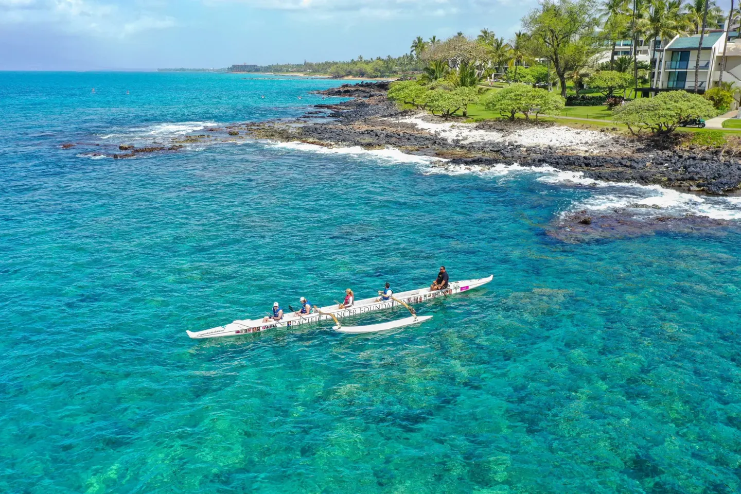 Outrigger canoe on turquoise water along the shoreline near Hotel Wailea.