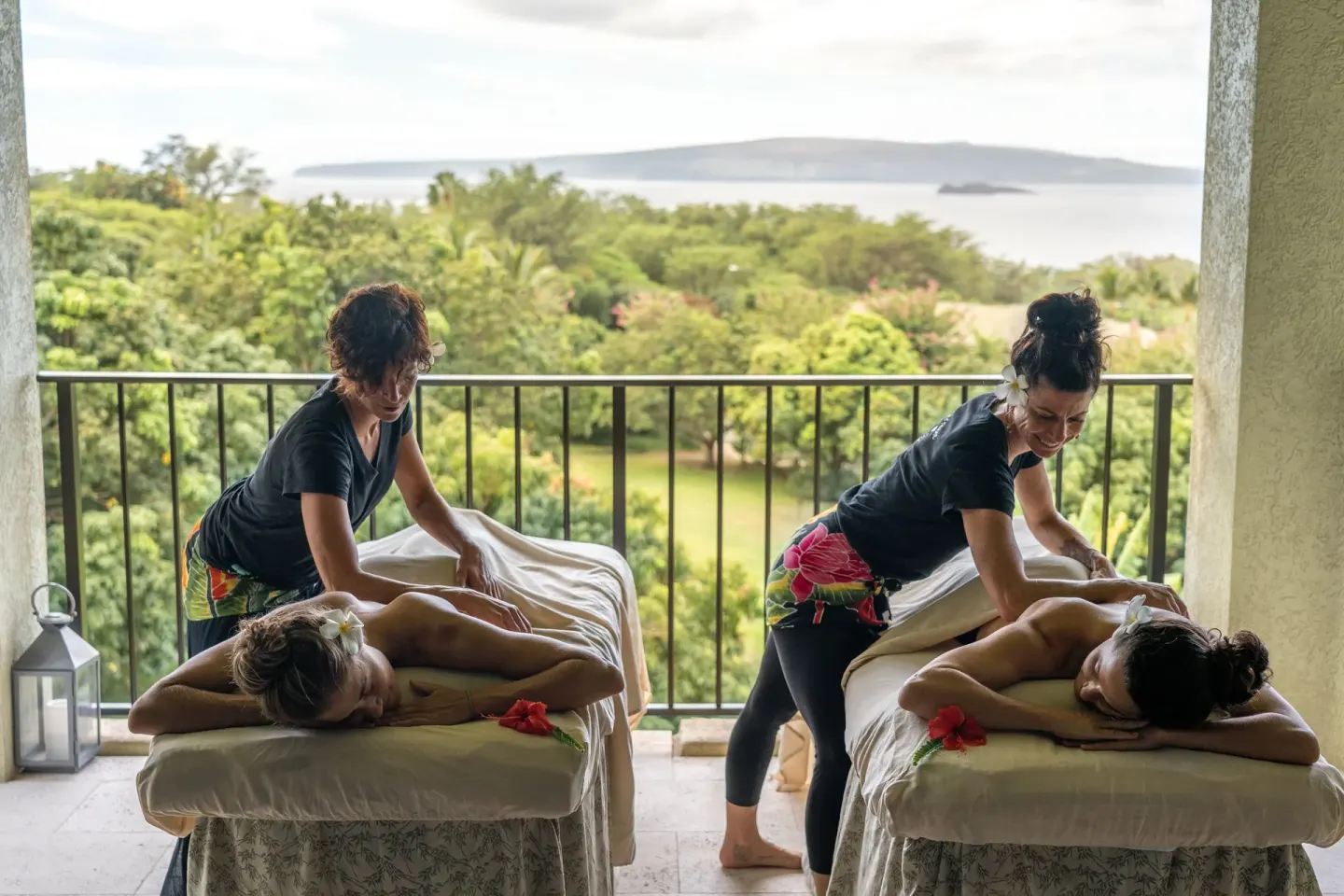 Two outdoor massage tables on a terrace overlooking greenery and ocean at Hotel Wailea.