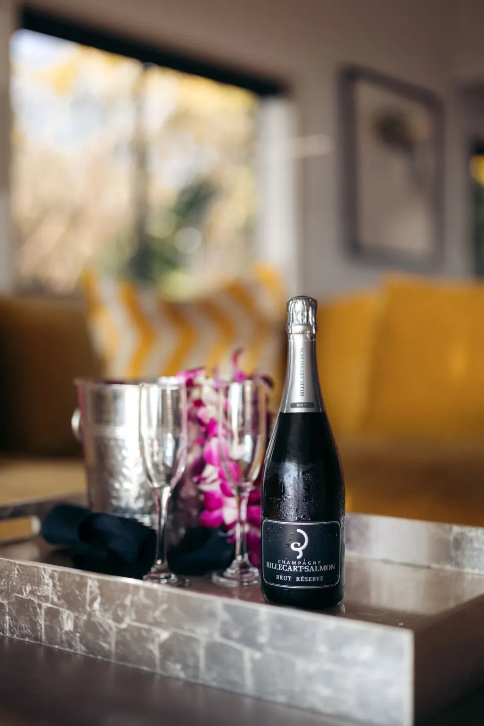 Celebration tray with sparkling wine, glasses, and flowers in a suite at Hotel Wailea.