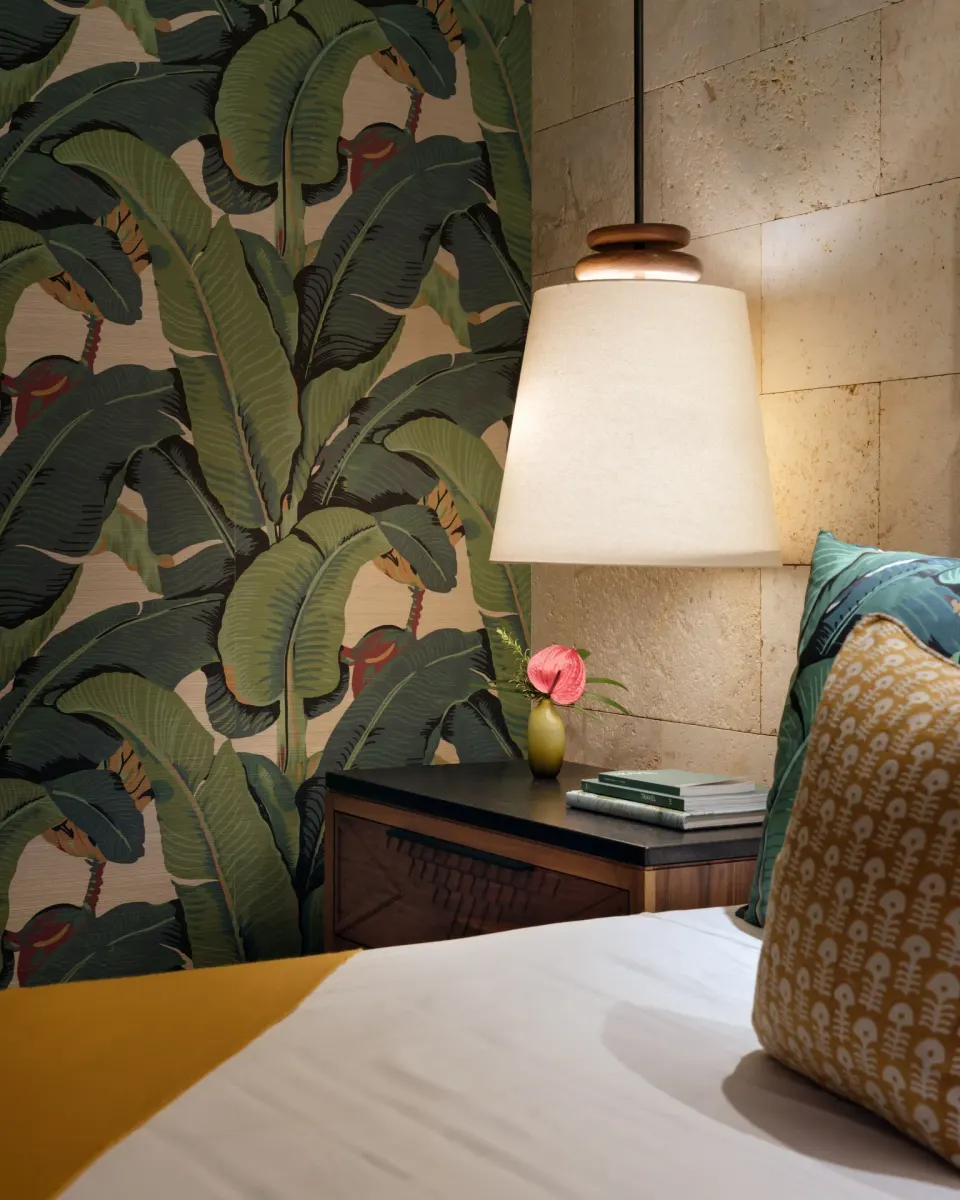 Ocean View Suite bedside lamp, tropical wallpaper, and pillows at Hotel Wailea.