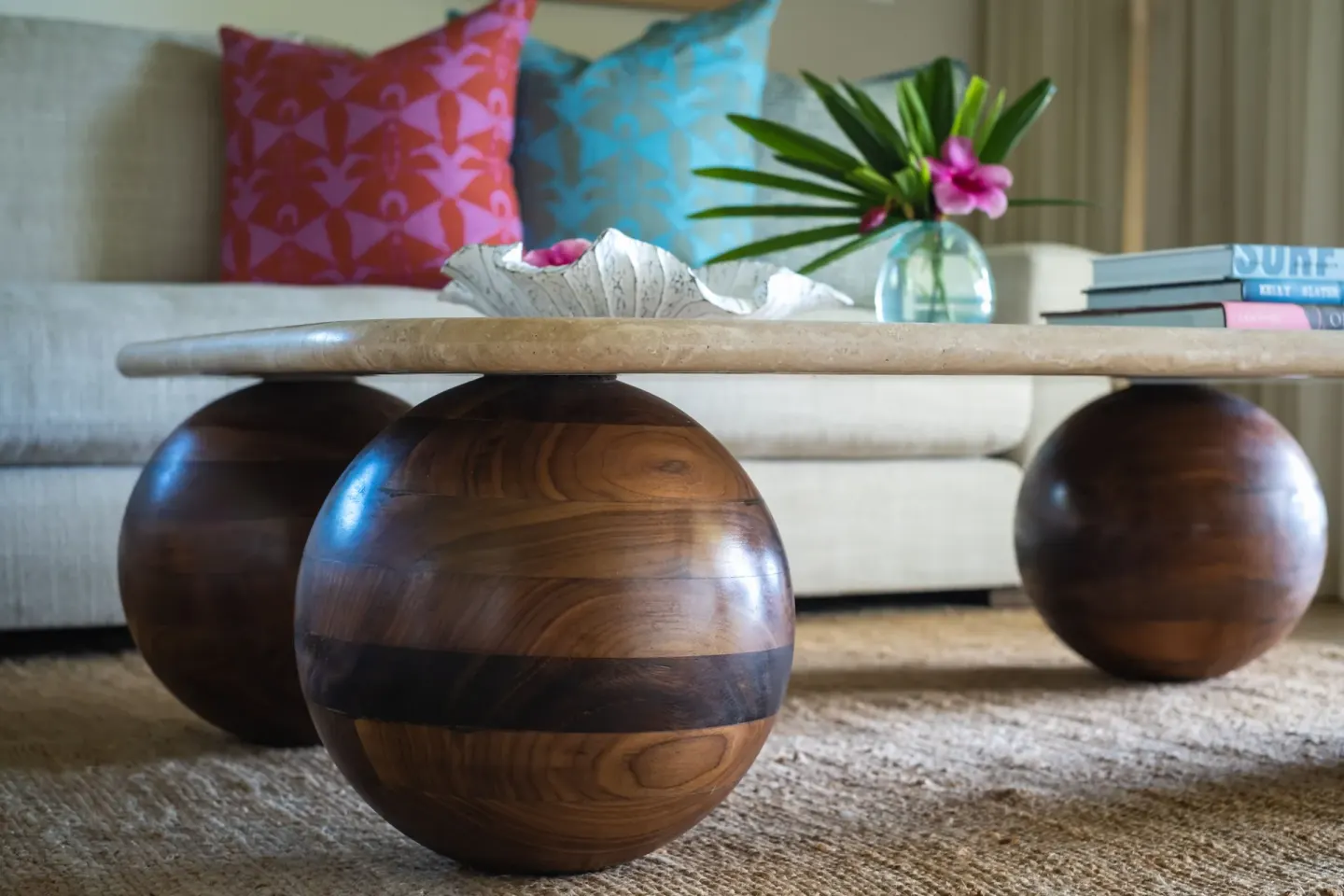 Ocean View Suite coffee table with rounded wood legs and bright pillows at Hotel Wailea.