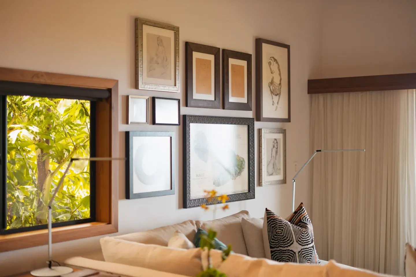 Ocean View Suite lounge corner with art wall and leafy window view at Hotel Wailea.