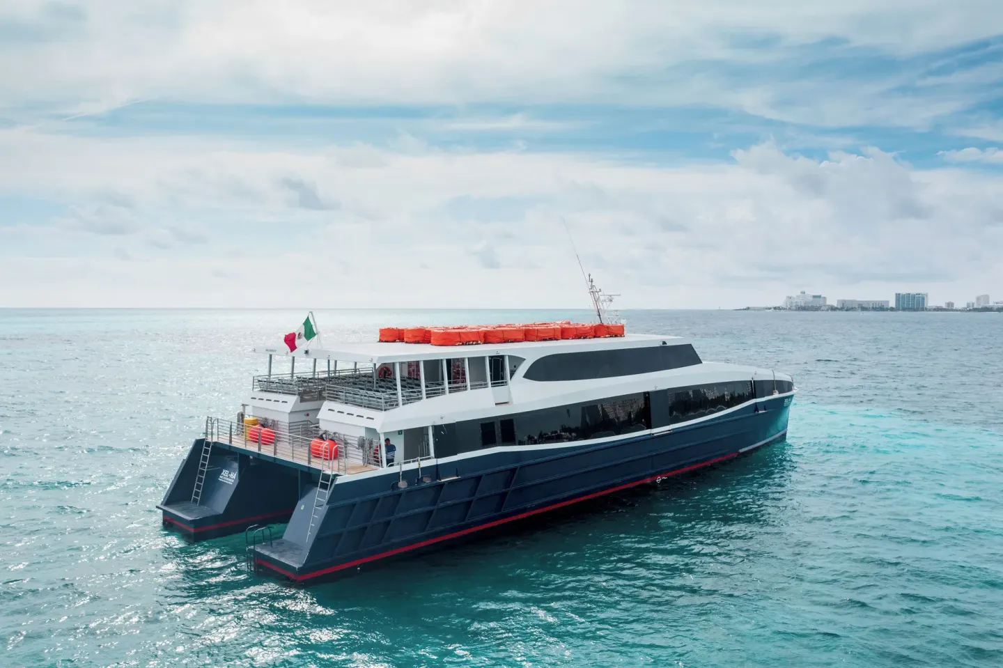 Passenger ferry on turquoise ocean water near Hotel Xcaret Arte.