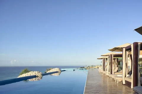 Rooftop infinity pool with ocean views and cabanas at Hotel Xcaret Arte.