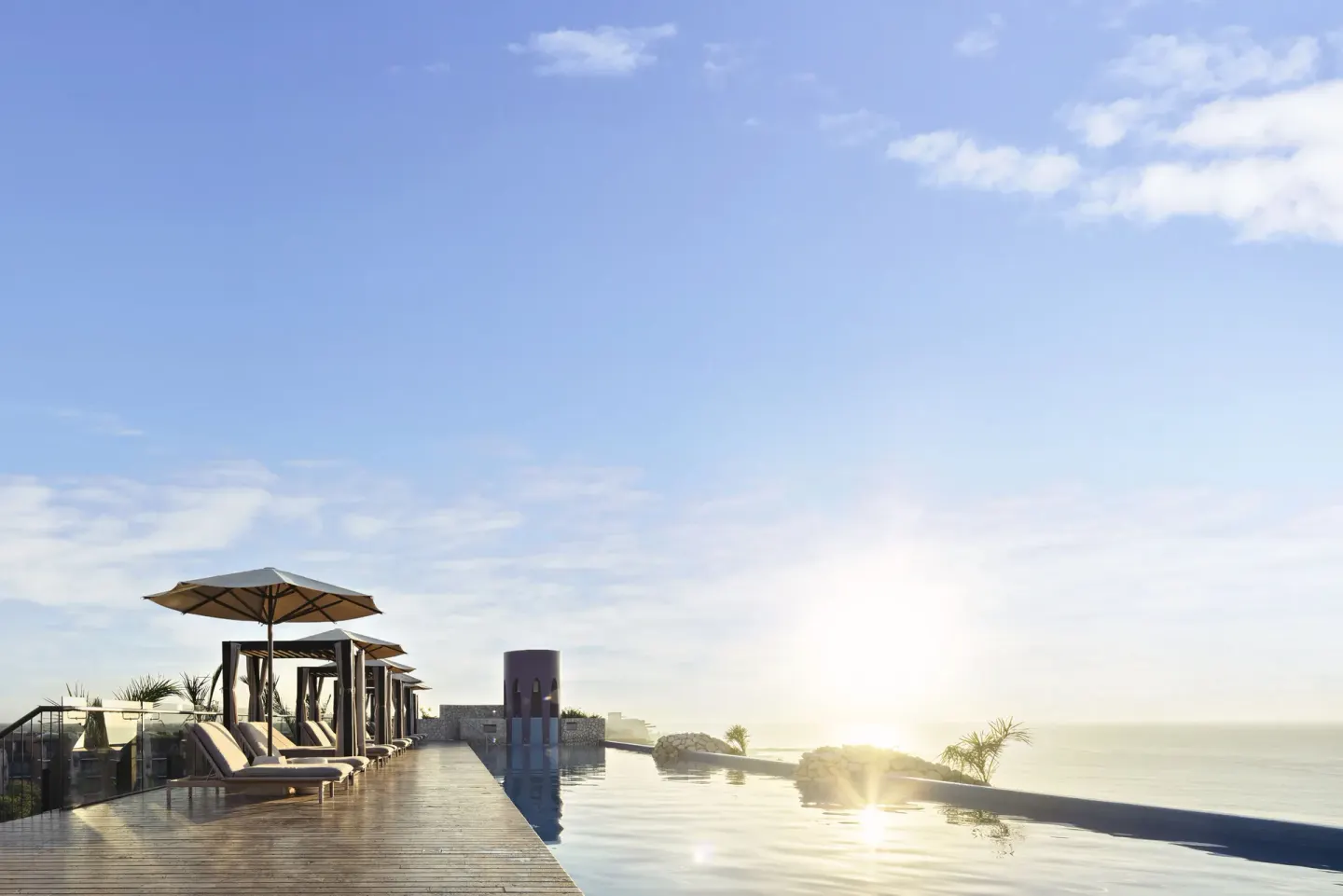 Sunrise over a rooftop infinity pool and ocean at Hotel Xcaret Arte.
