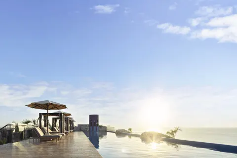 Sunrise over a rooftop infinity pool and ocean at Hotel Xcaret Arte.