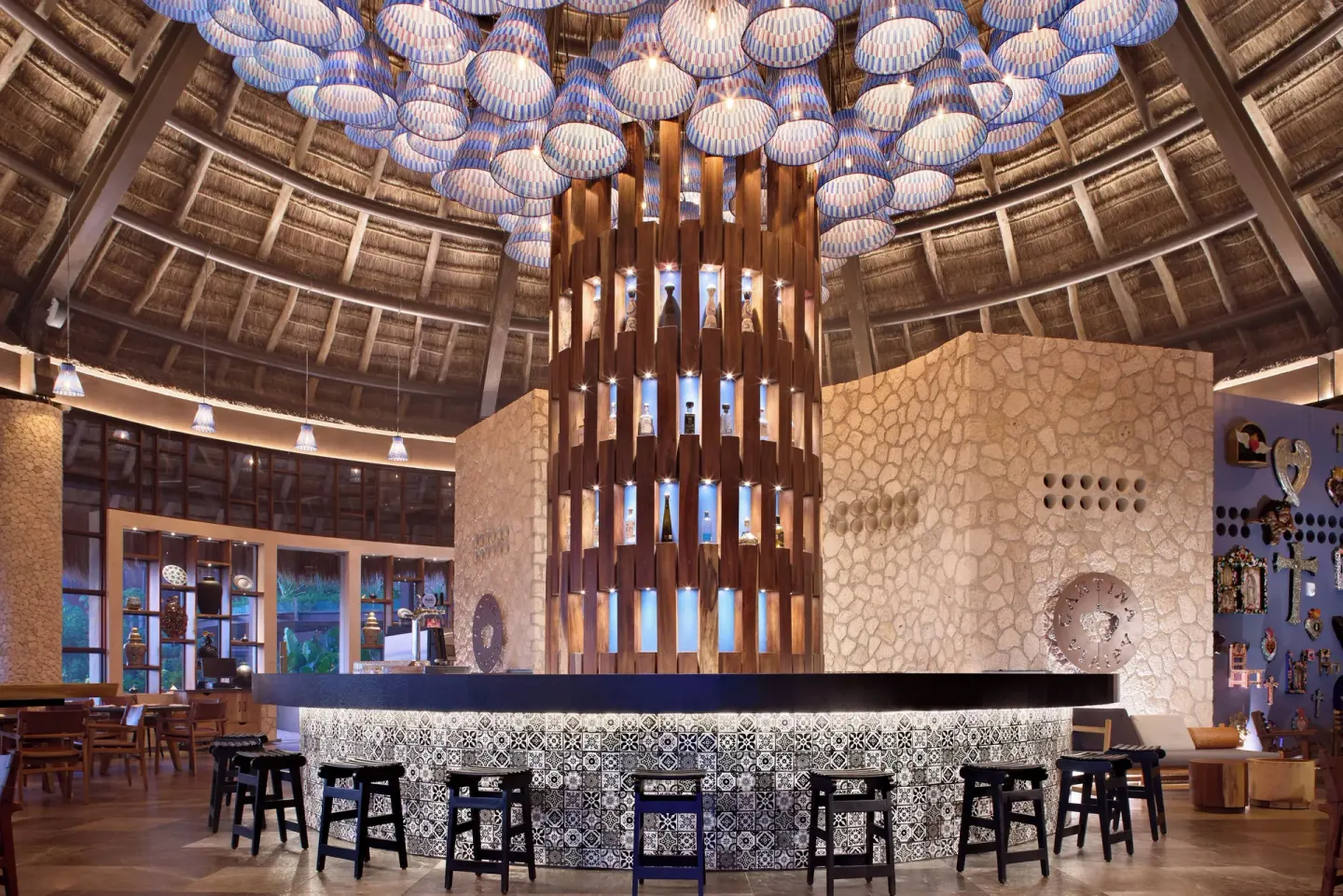 Circular tiled bar beneath blue pendant lights at Hotel Xcaret Arte.