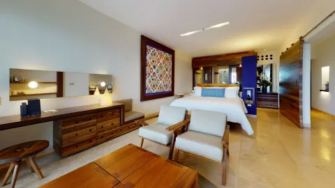 Junior Suite Ocean View room with king bed and seating area at Hotel Xcaret Arte.