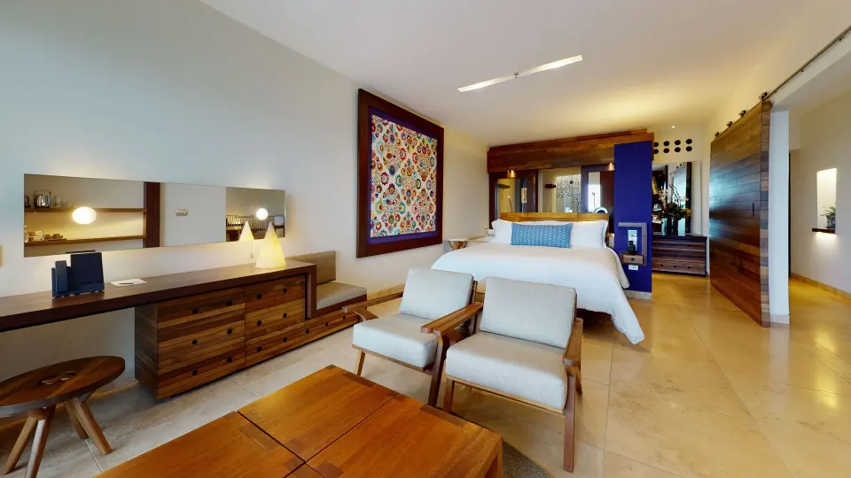 Junior Suite Ocean View room with king bed and seating area at Hotel Xcaret Arte.