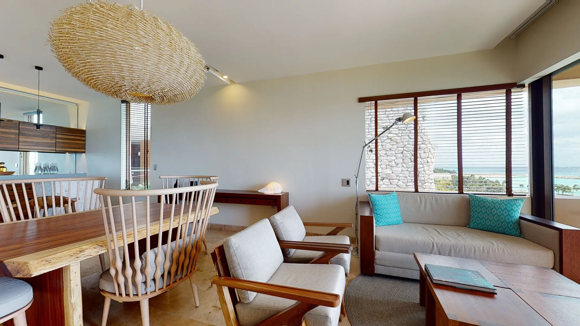 Junior Suite Oceanfront lounge and dining area at Hotel Xcaret Arte with ocean-facing windows.