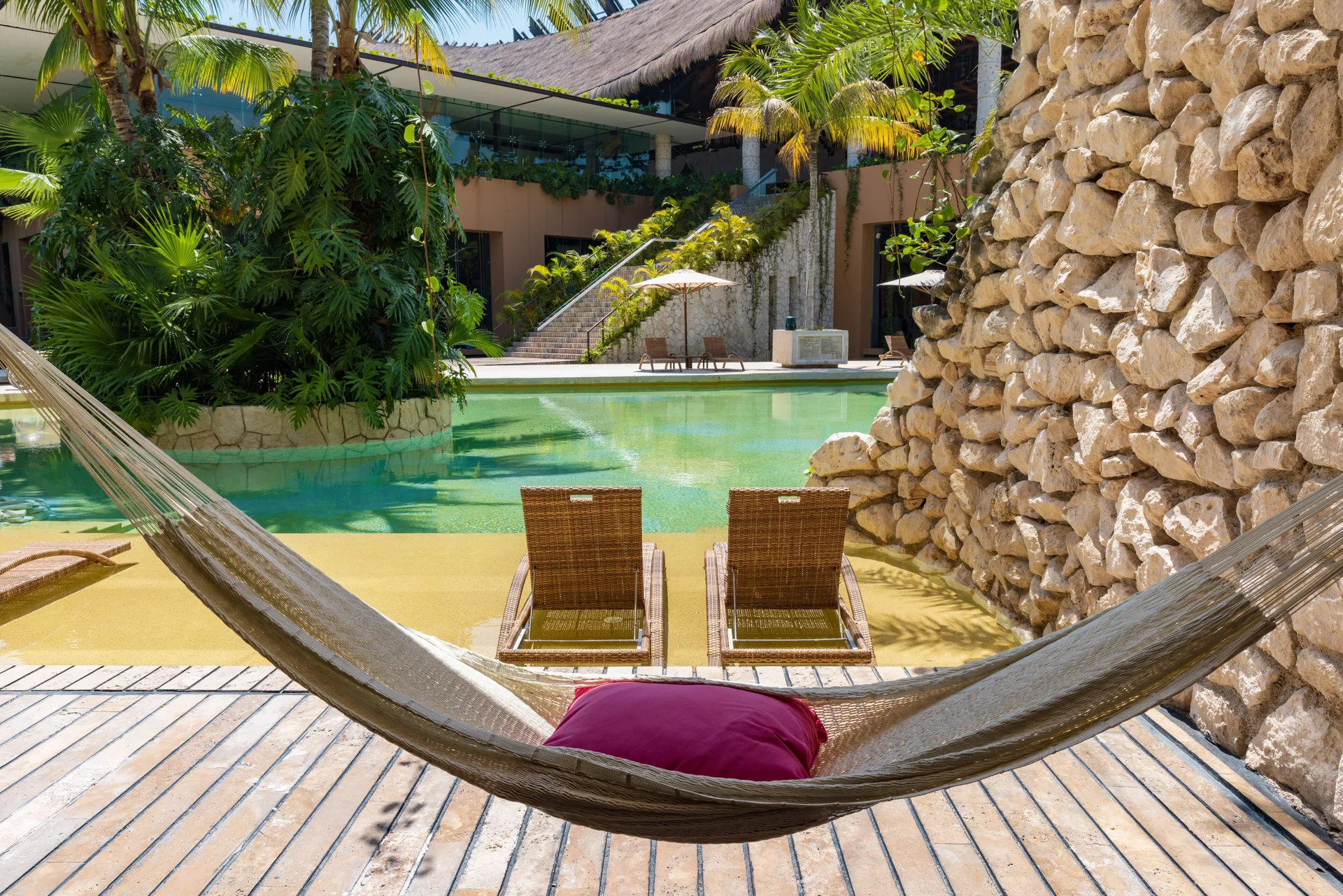 Garden Swim Up terrace with hammock, loungers, and pool at Hotel Xcaret Arte.