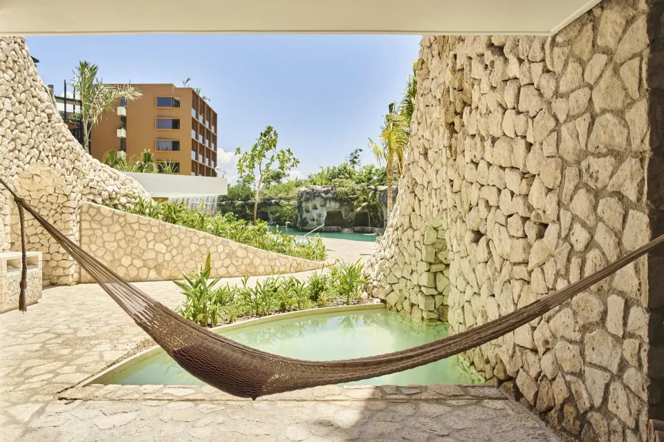 Garden Swim Up terrace hammock beside a shallow pool at Hotel Xcaret Arte.