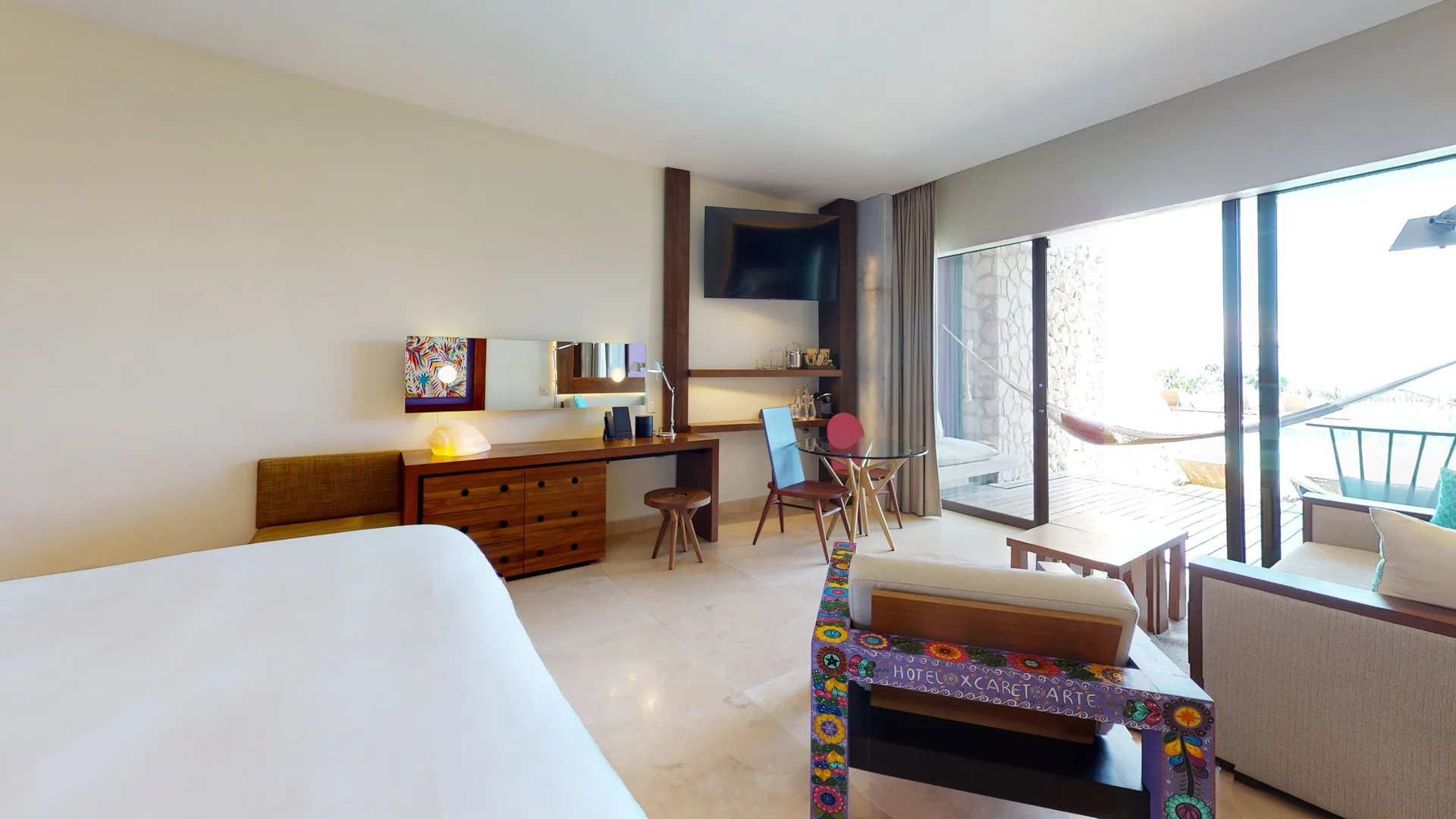 Oceanfront Swim Up room with king bed, seating, desk, and terrace at Hotel Xcaret Arte.