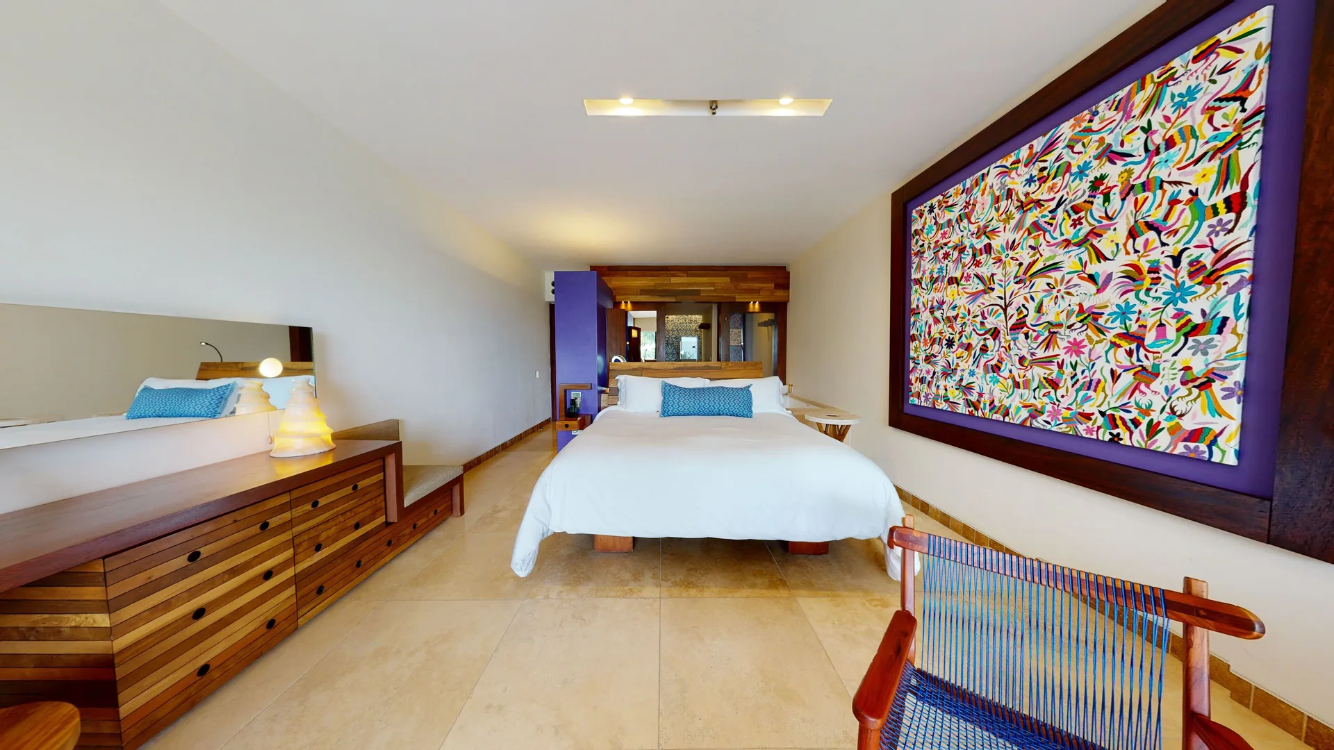 Oceanfront guest room with king bed and colorful wall art at Hotel Xcaret Arte.