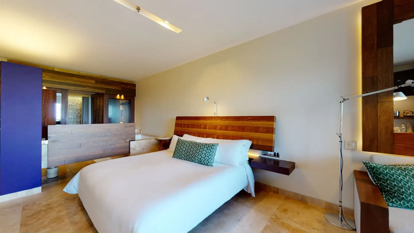 Ocean View Suite bedroom with king bed and open bath area at Hotel Xcaret Arte.
