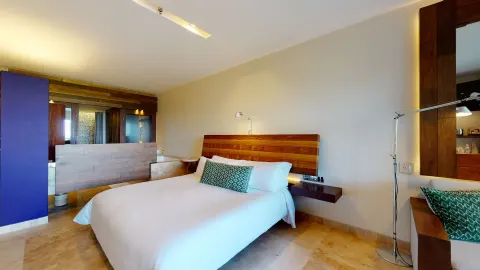 Ocean View Suite bedroom with king bed and open bath area at Hotel Xcaret Arte.