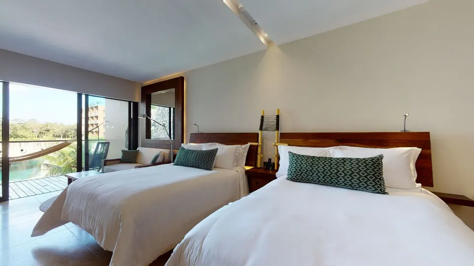Suite River King bedroom with two beds and balcony access at Hotel Xcaret Arte.