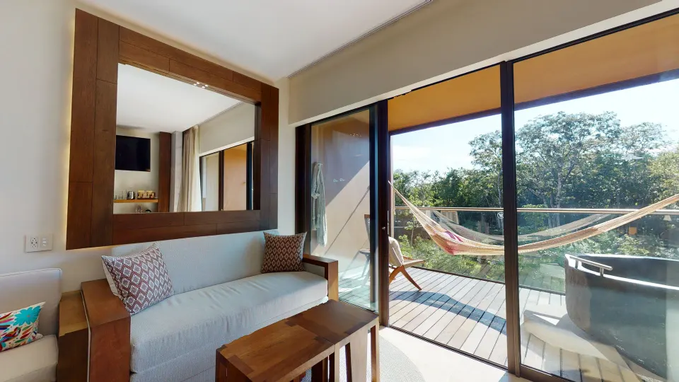Suite River Spa sofa and balcony hammock with outdoor tub at Hotel Xcaret Arte.