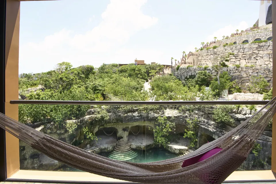Suite River View Jump Adults balcony hammock overlooking greenery at Hotel Xcaret Arte.
