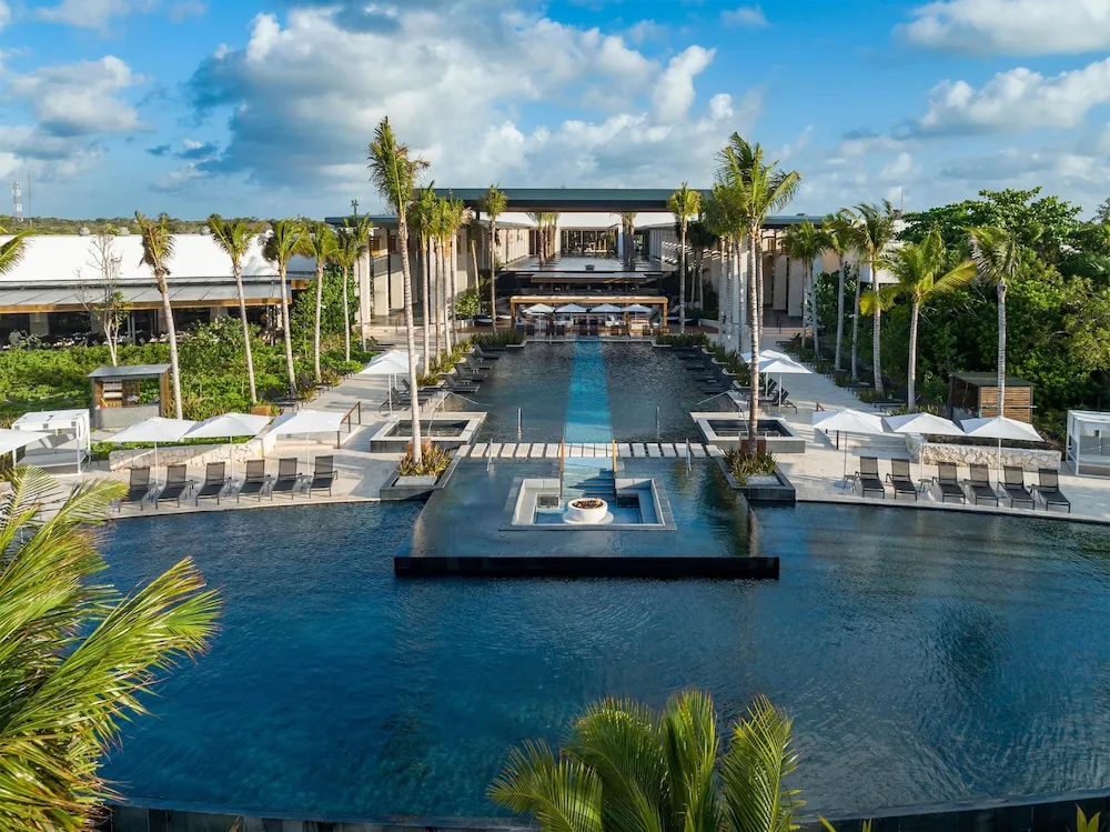 Conrad Tulum Playa del Carmen luxury beachfront resort with modern architecture, infinity pools, and pristine Caribbean beach setting.