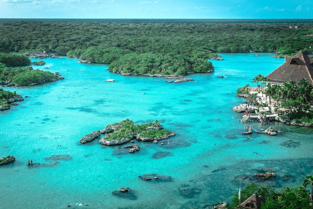 Aerial view of turquoise lagoon and forested coastline at Hotel Xcaret Mexico.