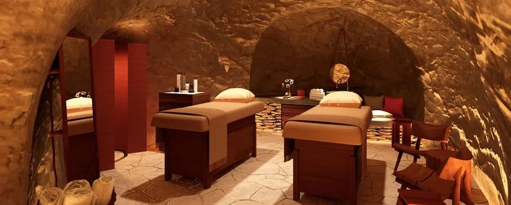 Cave-style spa treatment room with two massage tables at Hotel Xcaret Mexico.