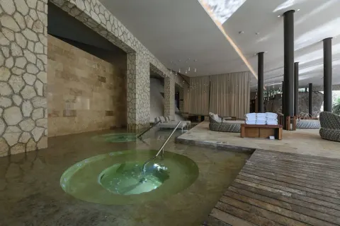 Indoor hydrotherapy pools and loungers in the spa at Hotel Xcaret Mexico.