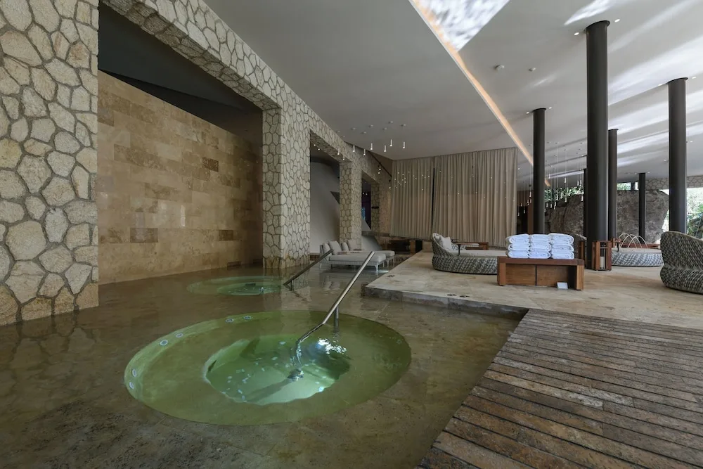 Indoor hydrotherapy pools and loungers in the spa at Hotel Xcaret Mexico.