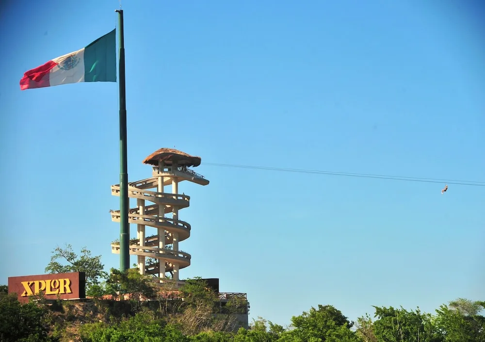 A Mexican flag and adventure tower are visible near Hotel Xcaret Mexico.