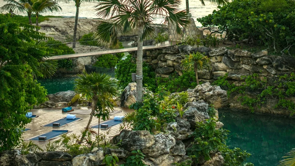Outdoor yoga deck by rocky water channels at Hotel Xcaret Mexico.