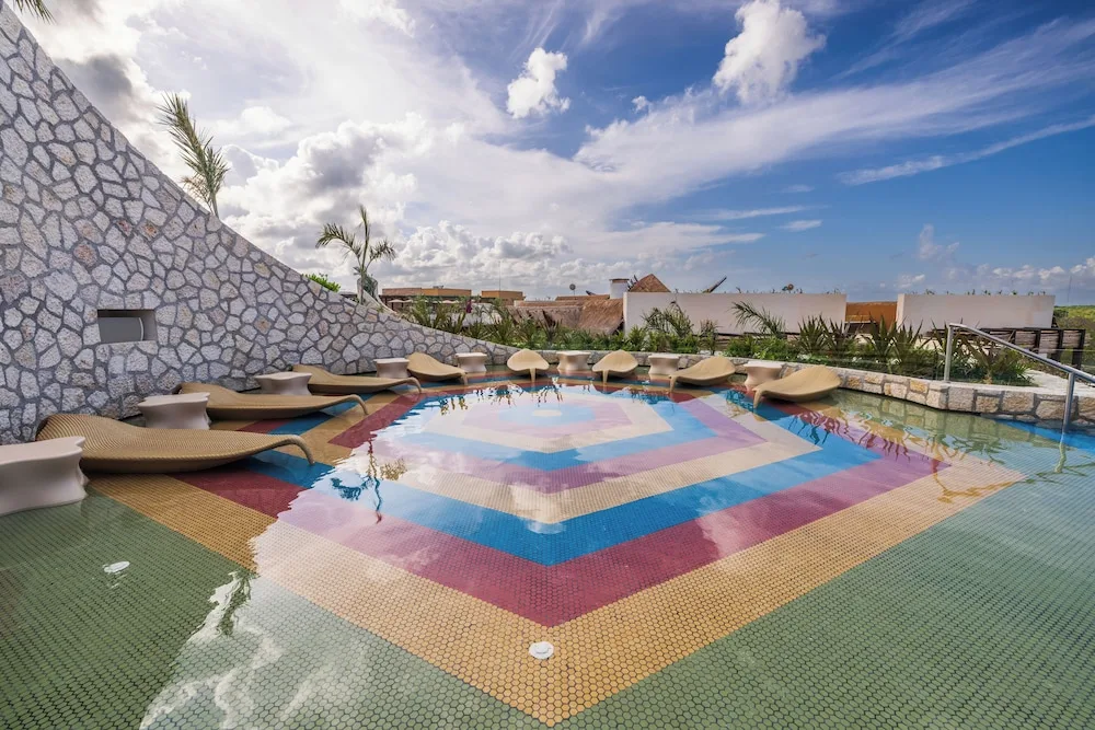 Rooftop shallow pool with colorful mosaic floor at Hotel Xcaret Mexico.