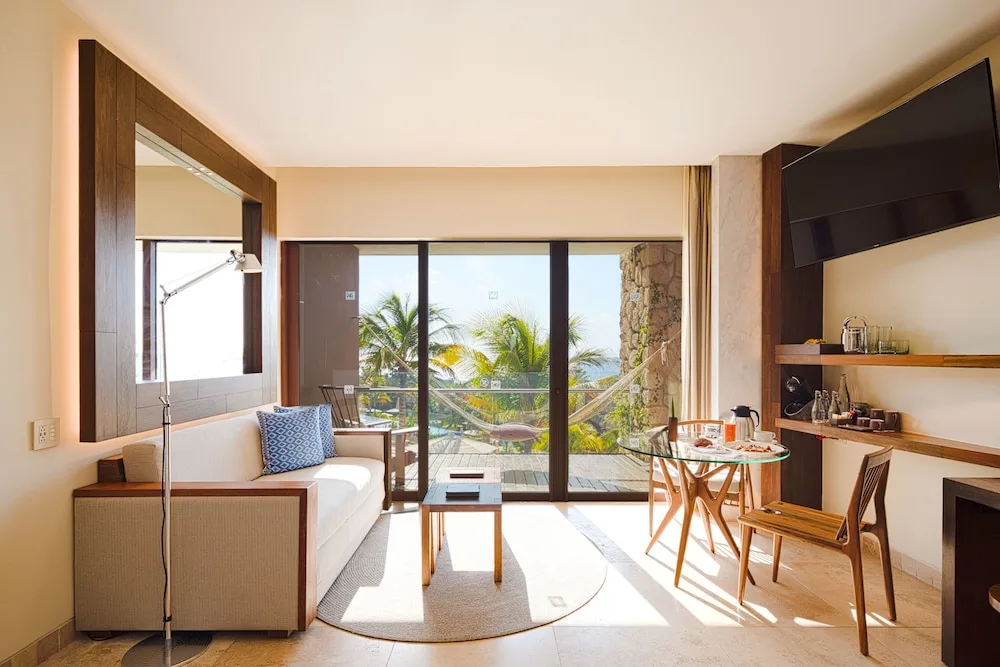 Oceanfront family suite living area with balcony hammock at Hotel Xcaret Mexico.