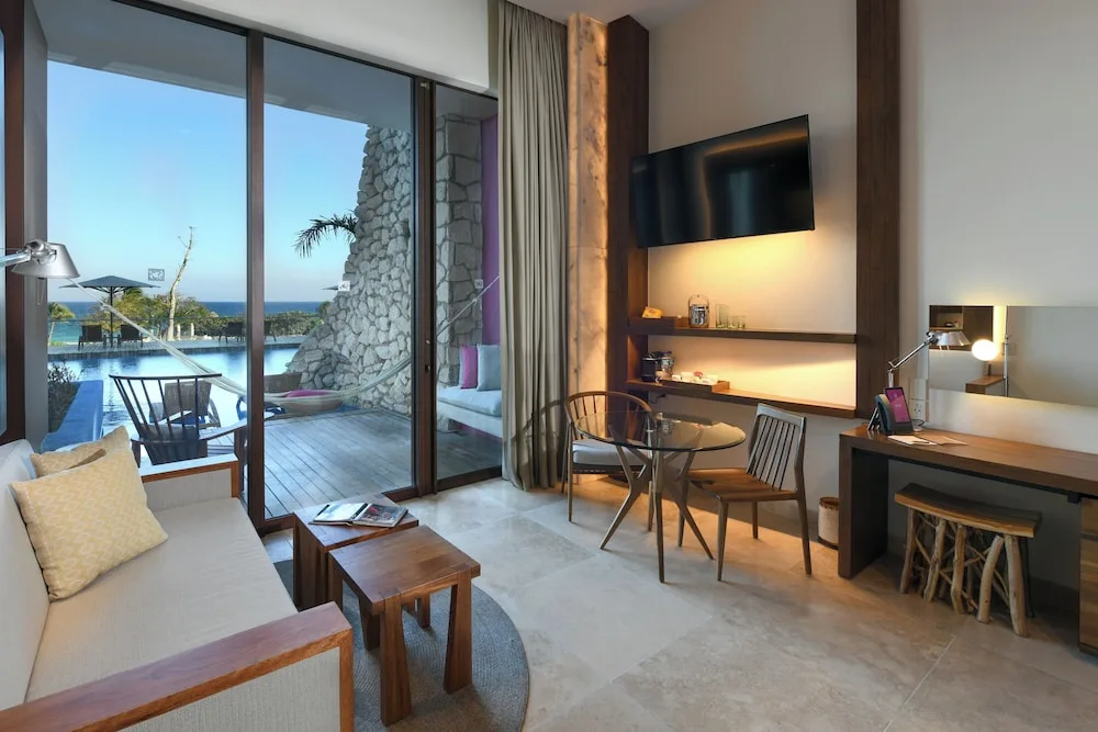 Oceanfront swim-up guest room sitting area and terrace at Hotel Xcaret Mexico.