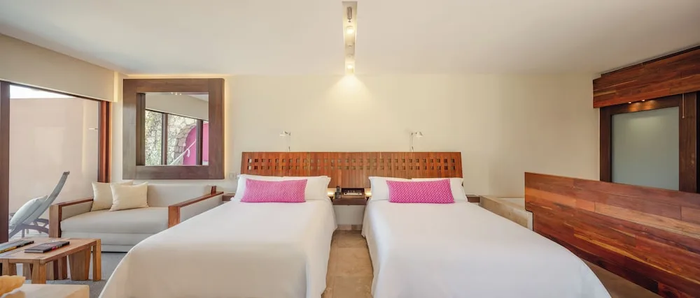 Swim-up garden room with two beds and sitting area at Hotel Xcaret Mexico.