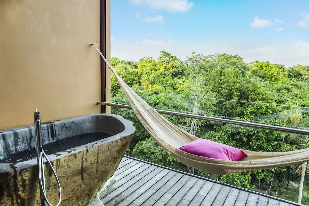 Garden Spa suite balcony with stone tub and hammock at Hotel Xcaret Mexico.