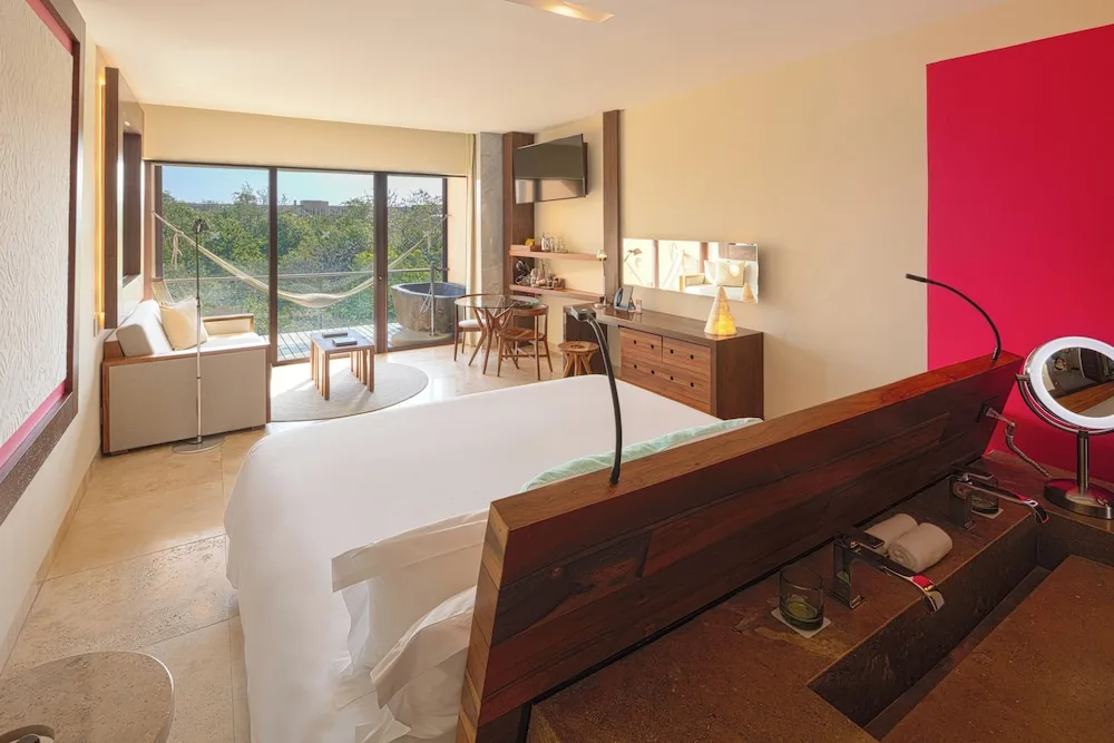 Garden Spa adults-only suite with king bed and open vanity at Hotel Xcaret Mexico.
