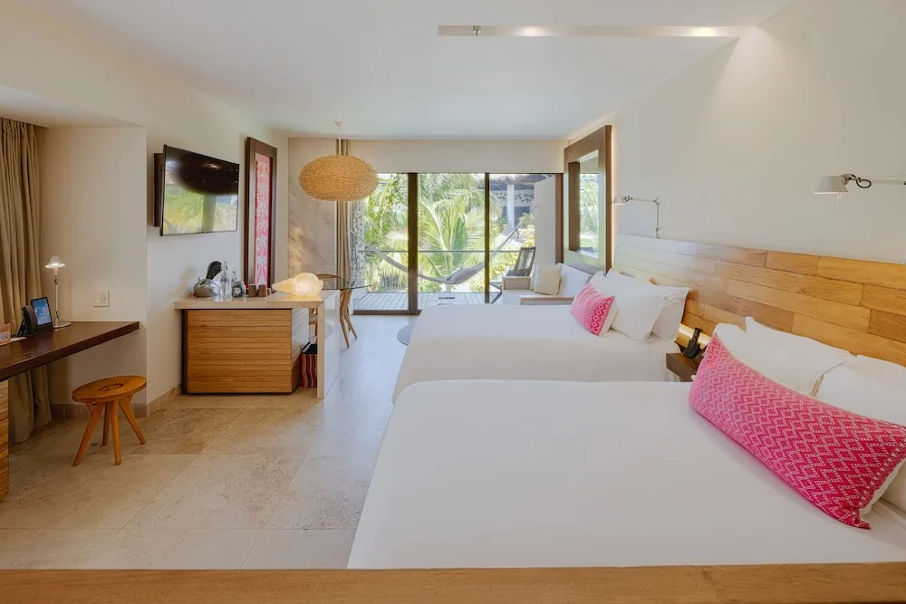 Suite Garden room with two beds and balcony hammock facing greenery at Hotel Xcaret Mexico.