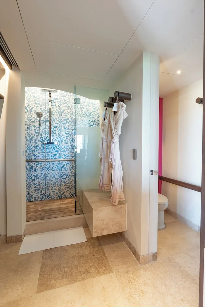 Master Suite bathroom with glass shower and robes at Hotel Xcaret Mexico.