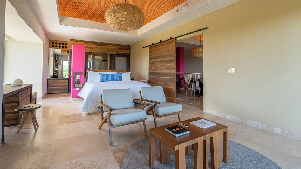 Master Suite bedroom with king bed and sitting area at Hotel Xcaret Mexico.